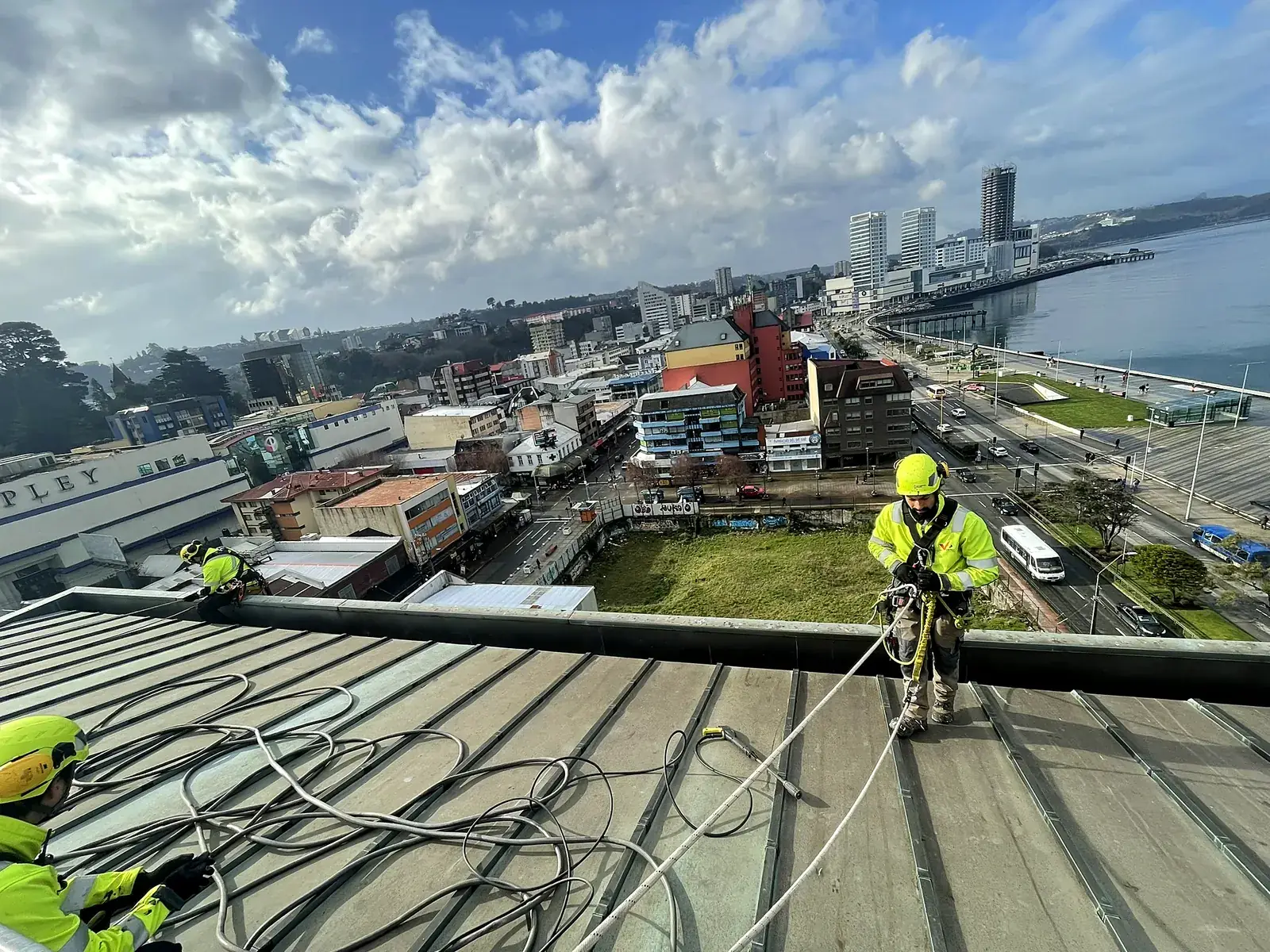 Equipo de VERTEC preparando el acceso por cuerdas en la cubierta de un edificio para trabajar en sus canaletas
