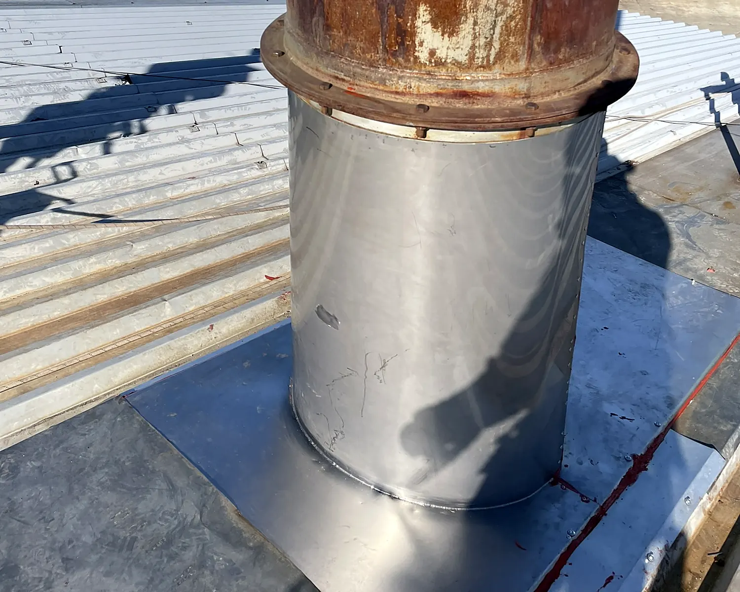 Forro de hojalatería instalado por VERTEC en el paso de una chimenea por una cubierta metálica