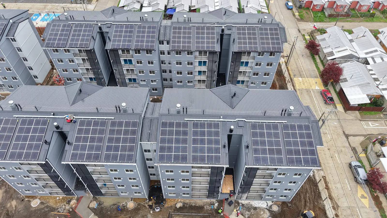 Vista aérea tomada con dron por VERTEC de techumbres con paneles solares en un conjunto de edificios