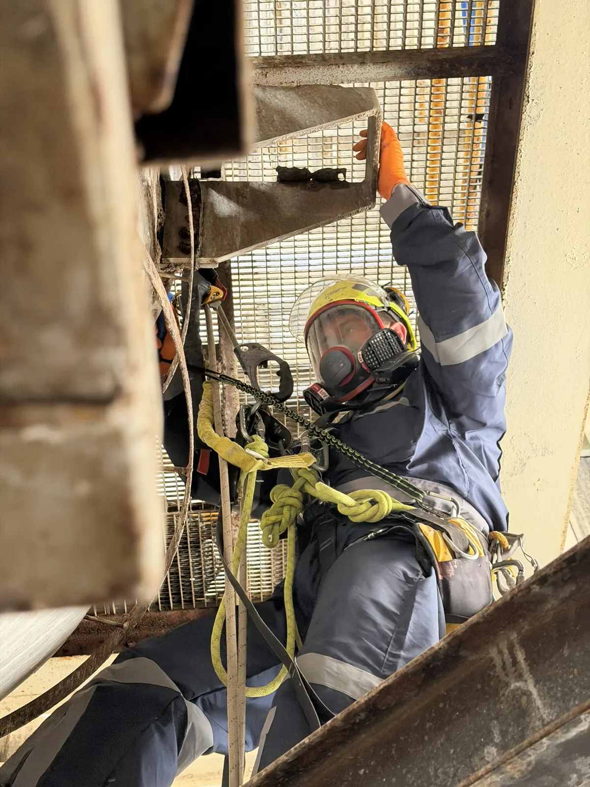 Técnico de VERTEC en acceso por cuerdas inspeccionando una estructura metálica de difícil acceso