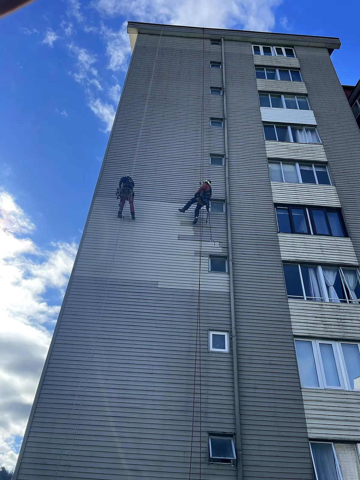 Técnicos de VERTEC terminando la instalación de revestimiento nuevo en la fachada de un edificio