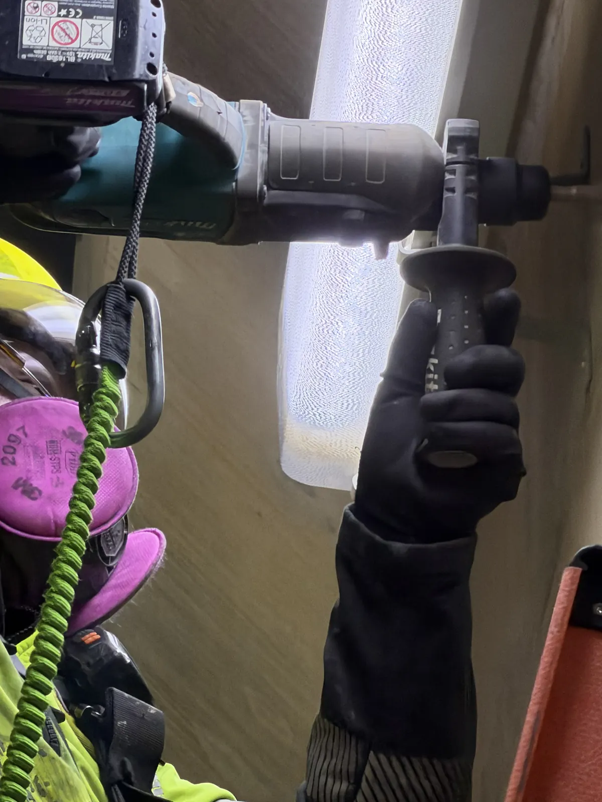 Técnico de VERTEC perforando con rotomartillo para instalar un punto de anclaje en altura